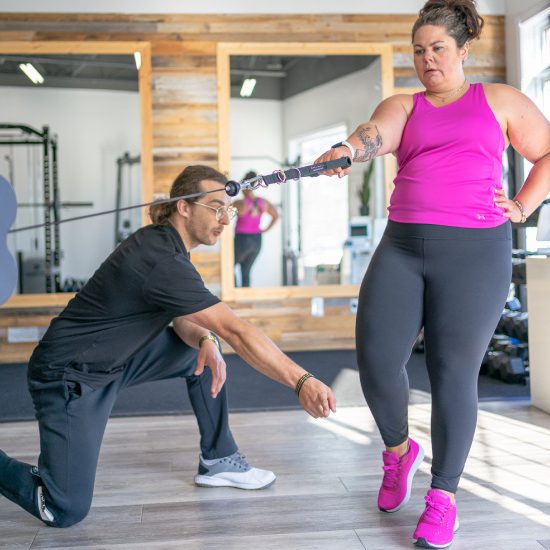 Personal fitness instructor teaching client correct body movement in gym Personal fitness instructor teaching client correct body movement in gym